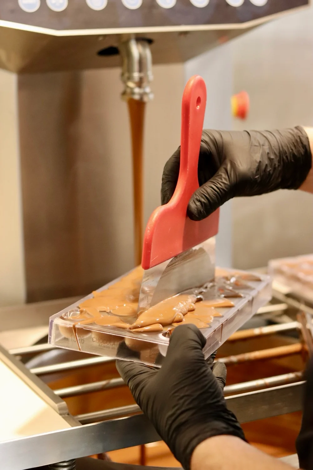 Pralinformen fylls med choklad för hand